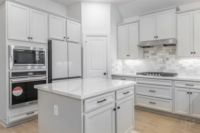 a kitchen with cabinets appliances and a counter space