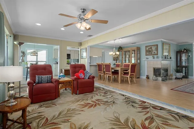 a living room with furniture a dining table and a chandelier