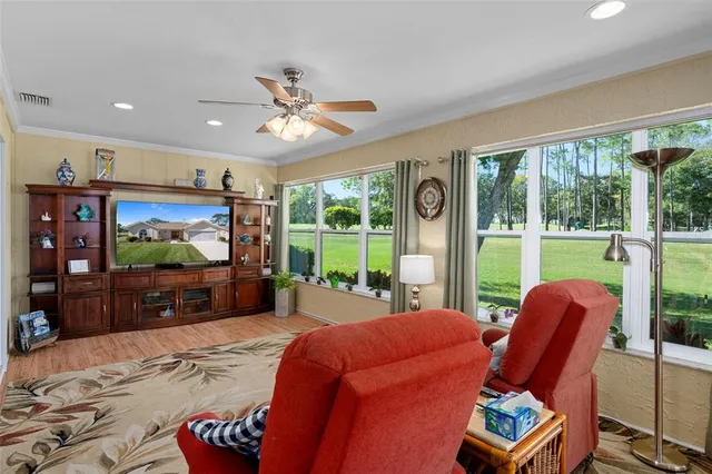 a living room with furniture a flat screen tv and a floor to ceiling window