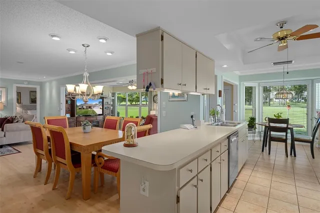 a large dining hall with stainless steel appliances kitchen island a table chairs and a refrigerator