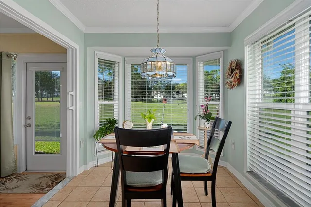 a dining room with furniture large windows and a chandelier