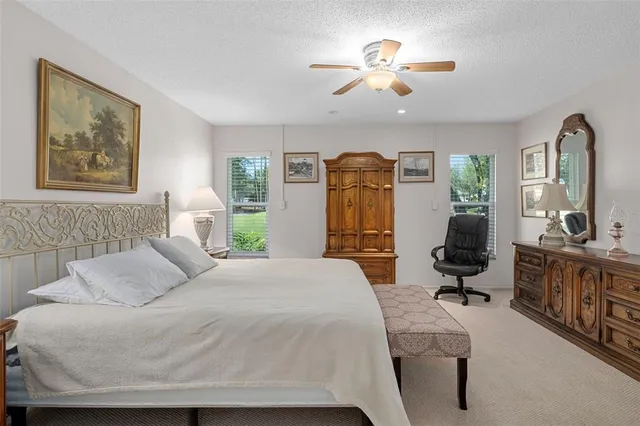 a bedroom with a bed a chandelier and a dresser