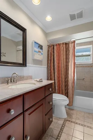 a bathroom with a granite countertop sink toilet and mirror