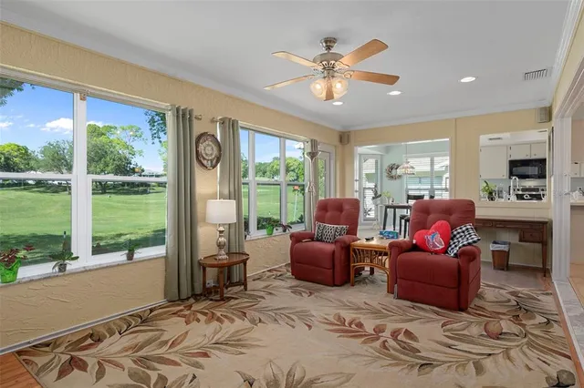 a living room with furniture and a floor to ceiling window