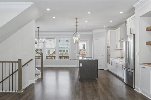 a open kitchen with white cabinets and stainless steel appliances