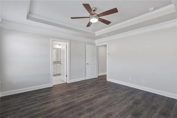 an empty room with wooden floor and ceiling fan