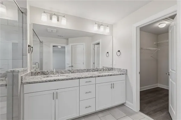 a bathroom with a granite countertop sink double and mirror