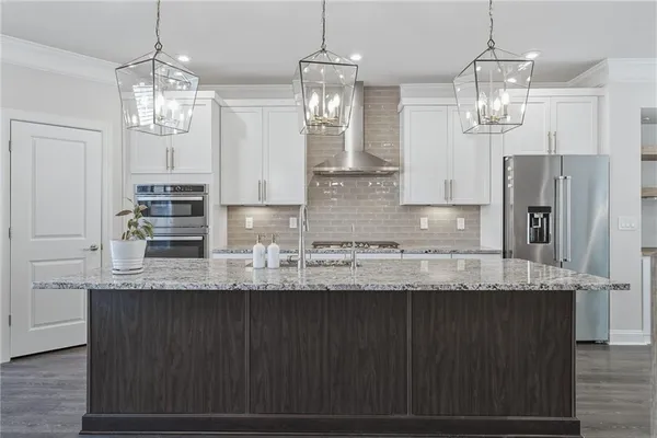 a view of a kitchen with granite countertop stainless steel appliances a sink and a chandelier