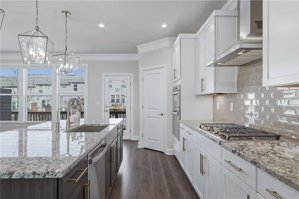 a kitchen with kitchen island granite countertop lots of counter top space and wooden floor