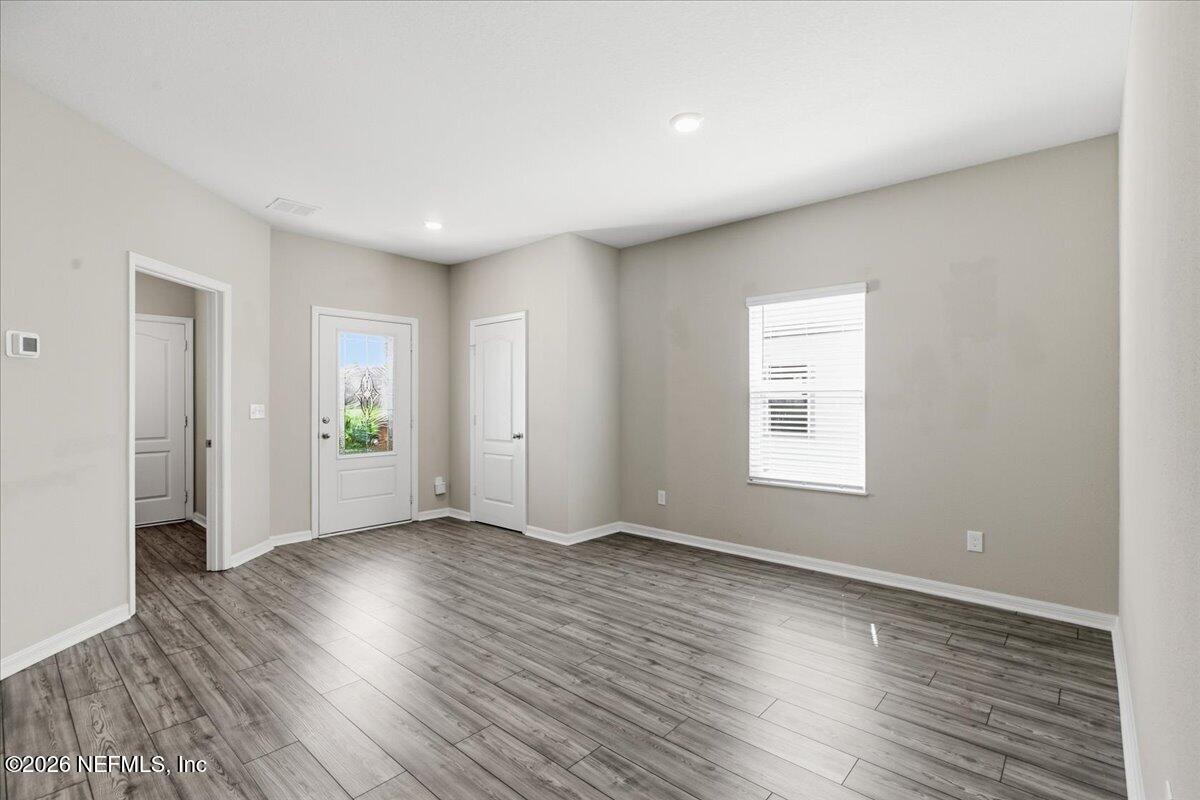 51 Tree Frog Way St. Augustine, FL 32095 - Photo 3 of 21 an empty room with wooden floor and windows