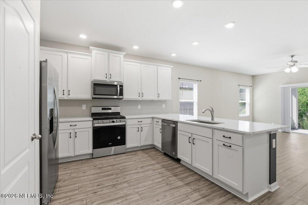 51 Tree Frog Way St. Augustine, FL 32095 - Photo 6 of 21 a kitchen with stainless steel appliances granite countertop a stove top oven a sink and cabinets