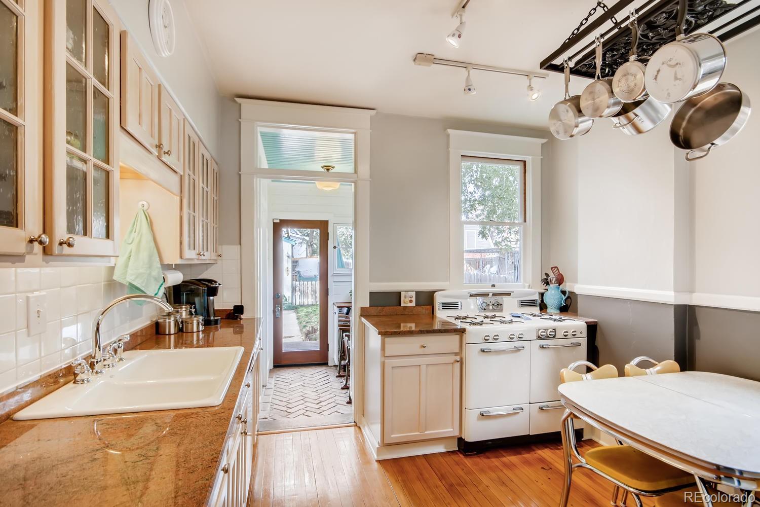 3345 Raleigh Street Denver, CO 80212 - Photo 12 of 27 a kitchen that has a sink a stove and chairs