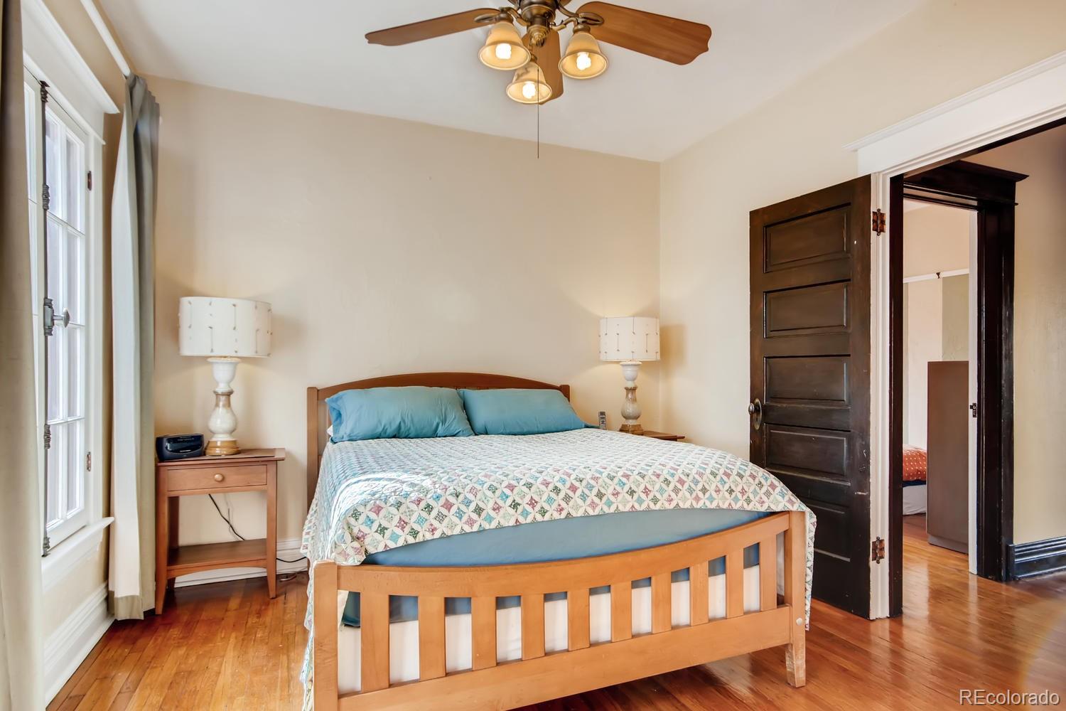 3345 Raleigh Street Denver, CO 80212 - Photo 17 of 27 a bedroom with a bed a table and wooden floor