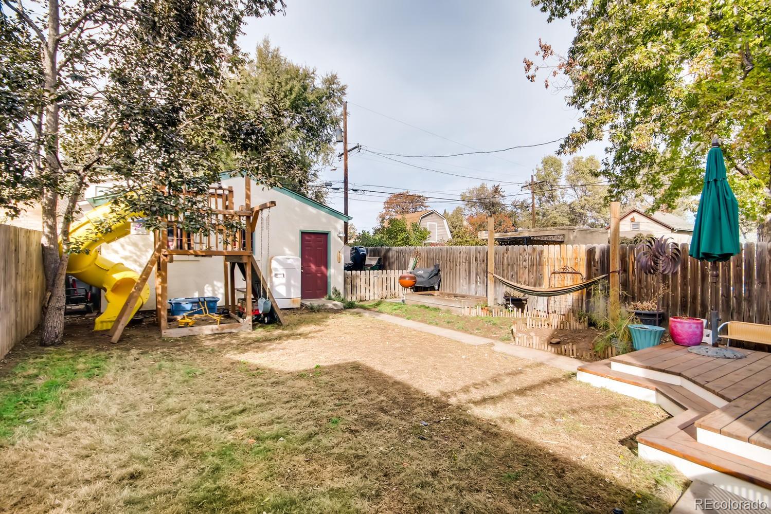3345 Raleigh Street Denver, CO 80212 - Photo 26 of 27 a view of a white house with a large tree and wooden fence