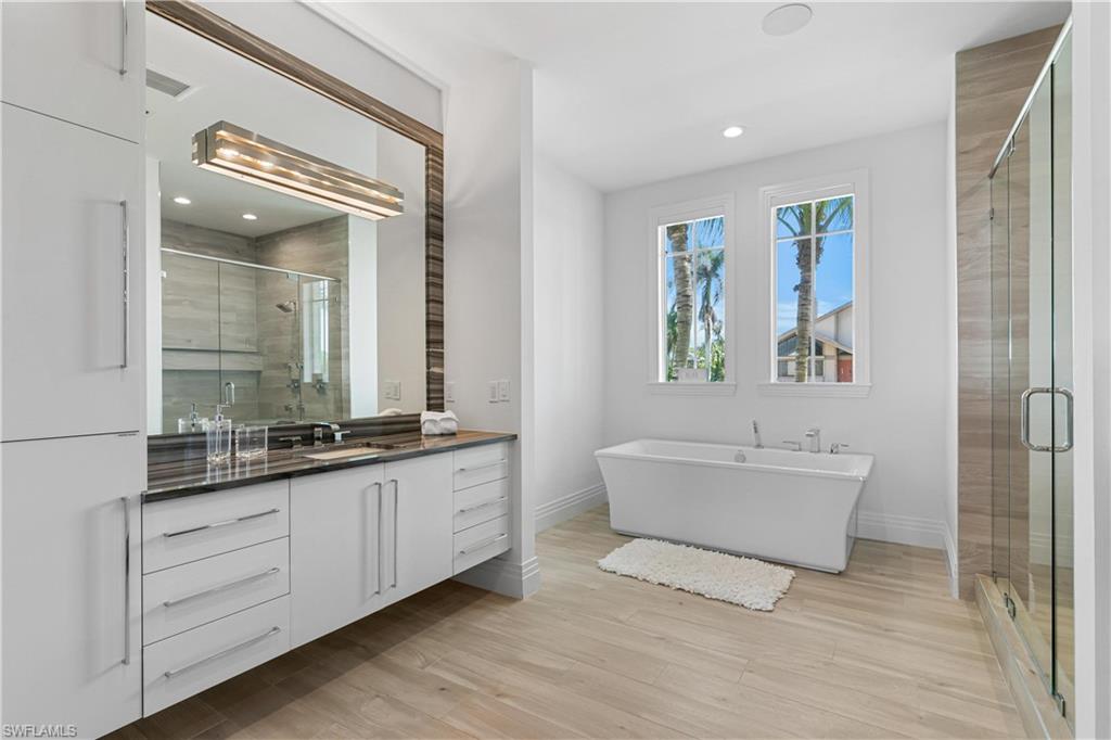 549 Hernando Drive Marco Island, FL 34145 - Photo 12 of 34 a bathroom with a double vanity sink a mirror and a bathtub