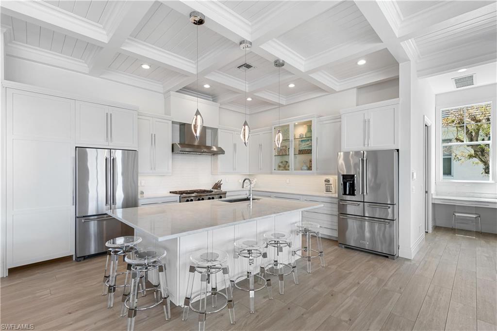 549 Hernando Drive Marco Island, FL 34145 - Photo 8 of 34 a kitchen with refrigerator a stove a microwave and wooden floor