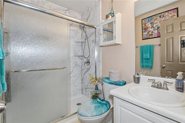 a bathroom with a sink a toilet and shower