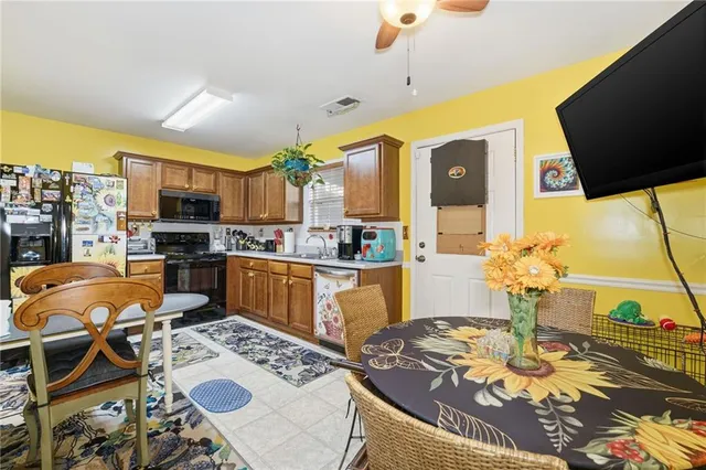 a kitchen with stainless steel appliances granite countertop a stove a sink dishwasher a dining table and chairs with wooden floor