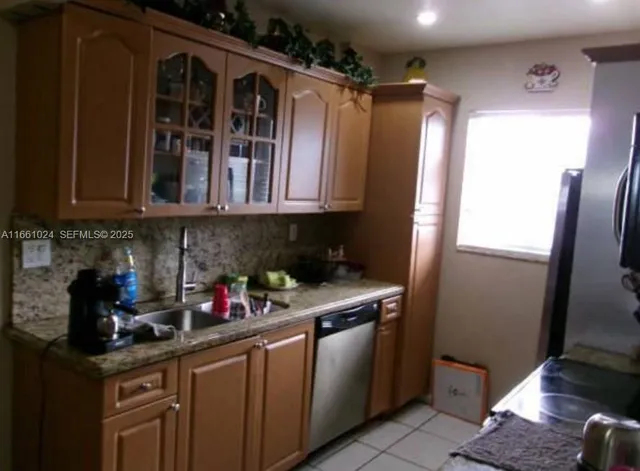 a kitchen with stainless steel appliances granite countertop a refrigerator and a sink