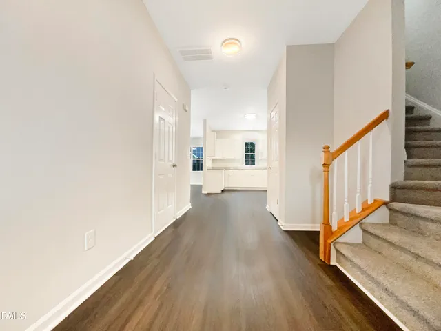 a view of a hallway with wooden floor and staircase