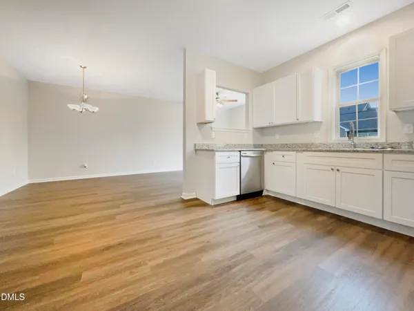 a view of a kitchen with granite countertop stainless steel appliances a sink and cabinets