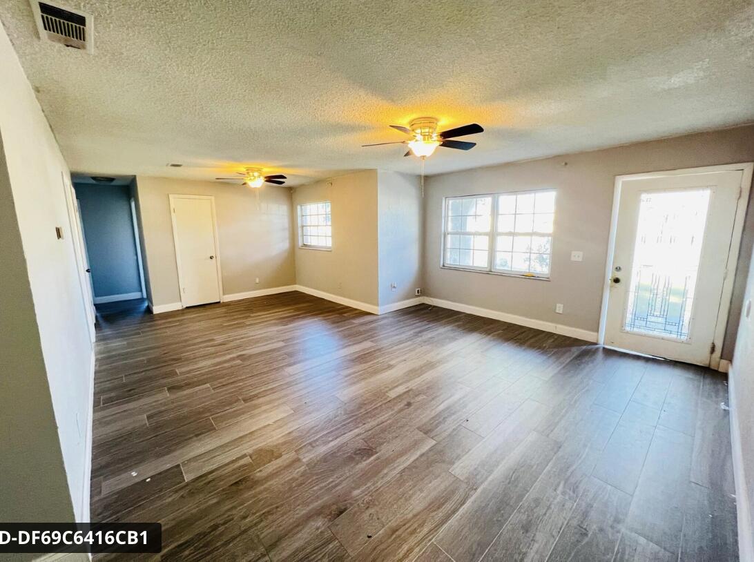 901 Hickory Street, Unit A Fort Pierce, FL 34947 - Photo 5 of 7 an empty room with wooden floor and windows