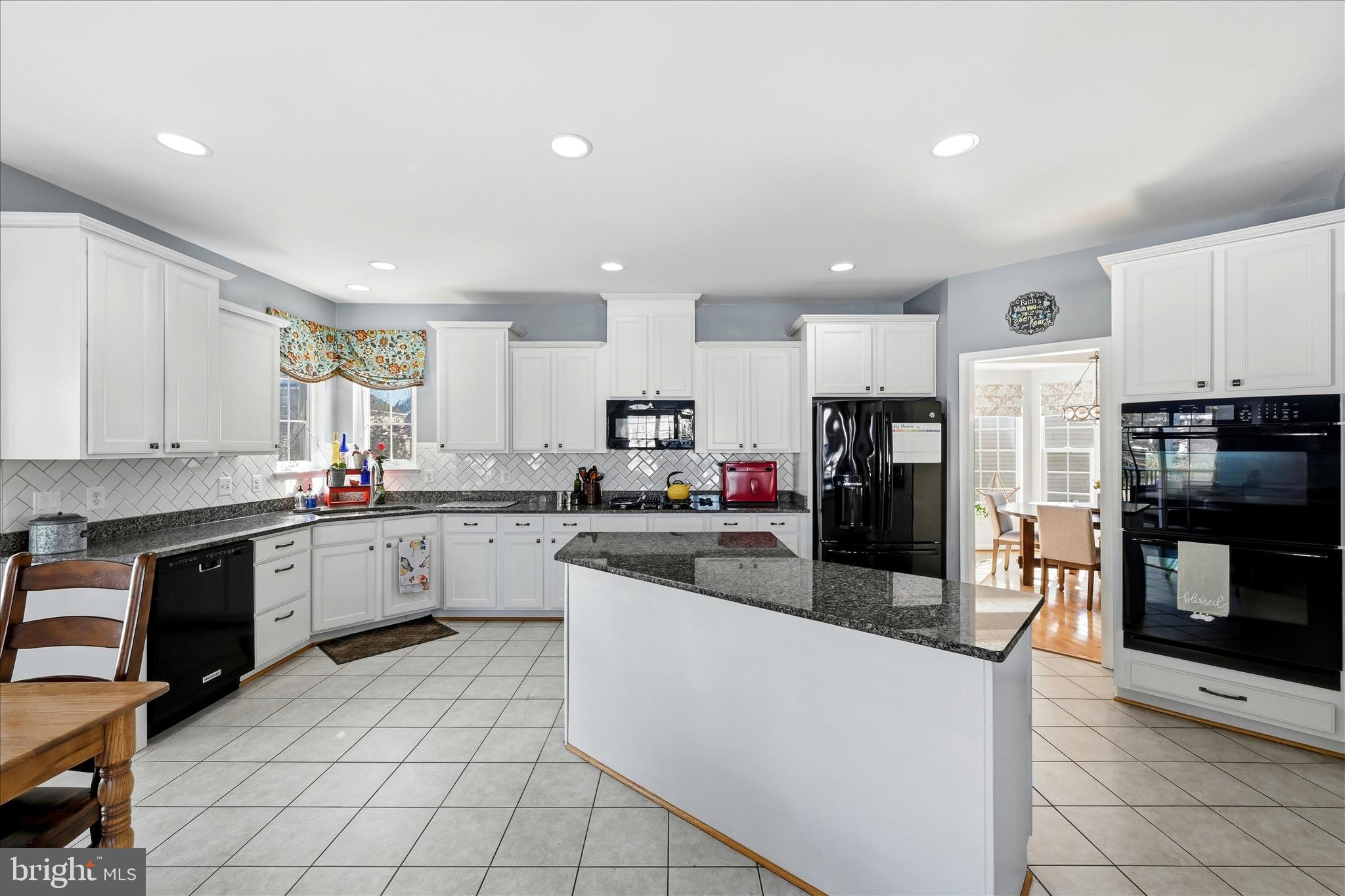 105 Garret Court Stephenson, VA 22656 - Photo 28 of 97 a large kitchen with stainless steel appliances lots of white cabinets a sink dishwasher a stove and a refrigerator with wooden floor