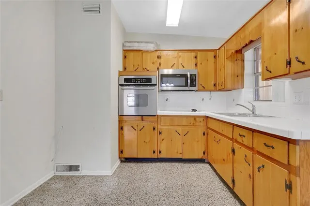 a kitchen with stainless steel appliances a sink and a refrigerator