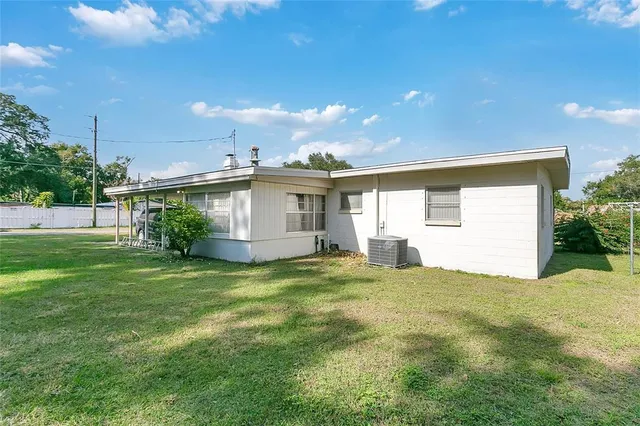 a view of a backyard with plants and large tree