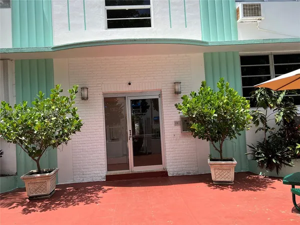 a front view of a house with potted plants