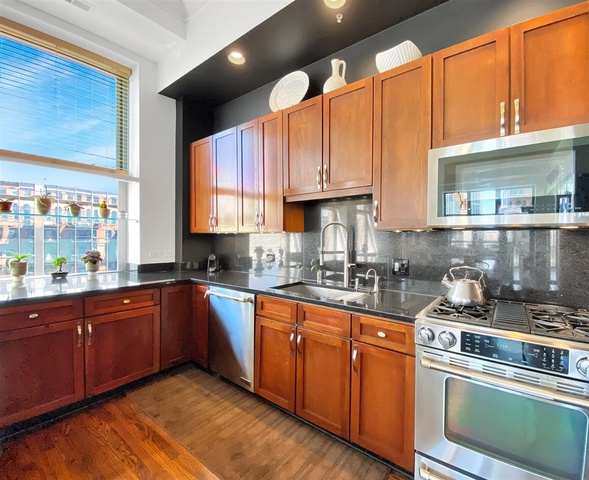 165 North Canal Street, Unit 1412 Chicago, IL 60606 - Photo 12 of 38 a kitchen with stainless steel appliances granite countertop a sink a stove and cabinets