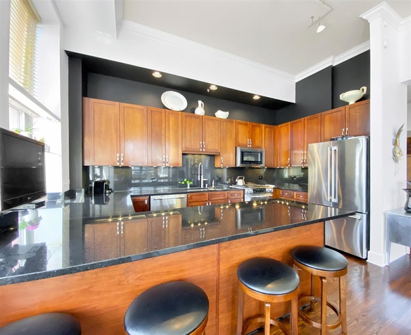 165 North Canal Street, Unit 1412 Chicago, IL 60606 - Photo 13 of 38 a dining room with stainless steel appliances granite countertop a stove a kitchen island a dining table and chairs