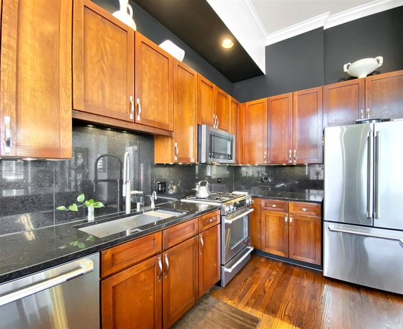 165 North Canal Street, Unit 1412 Chicago, IL 60606 - Photo 14 of 38 a kitchen with stainless steel appliances granite countertop a refrigerator a sink dishwasher a stove and white countertops with wooden floor