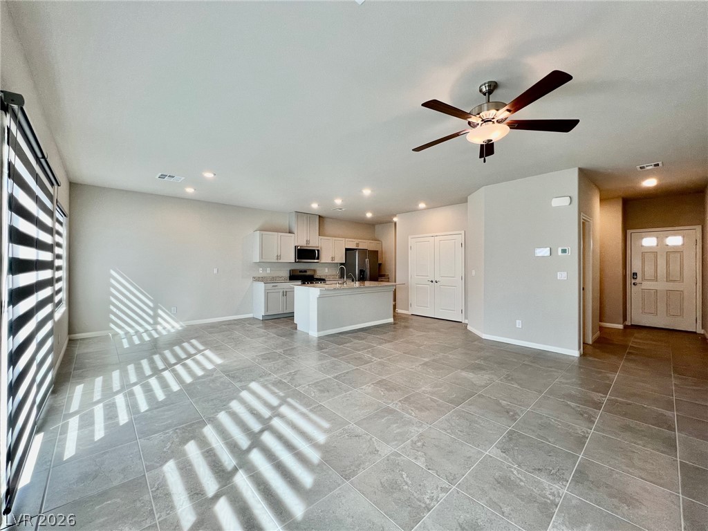 7845 Morganite Avenue Las Vegas, NV 89113 - Photo 21 of 21 A generous open floorplan seamlessly connects the kitchen and living areas, offering expansive tiled flooring.