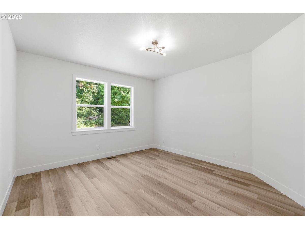 2147 Northeast Spitz Road Canby, OR 97013 - Photo 21 of 48 an empty room with wooden floor and windows