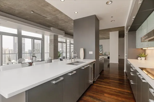 a large kitchen with kitchen island a large window a sink and cabinets