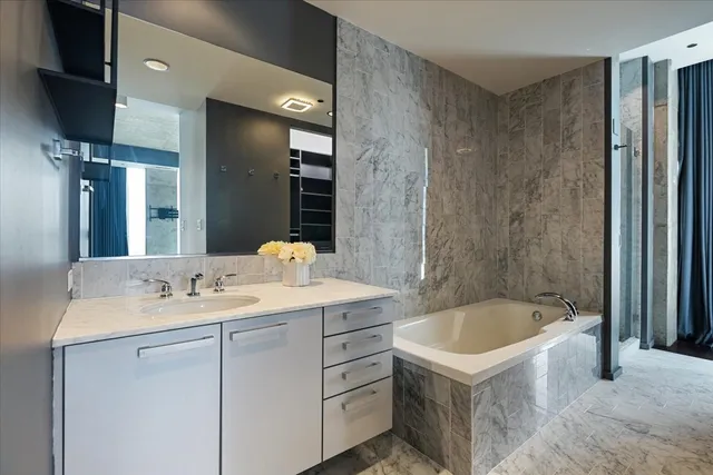 a bathroom with a tub sink and mirror