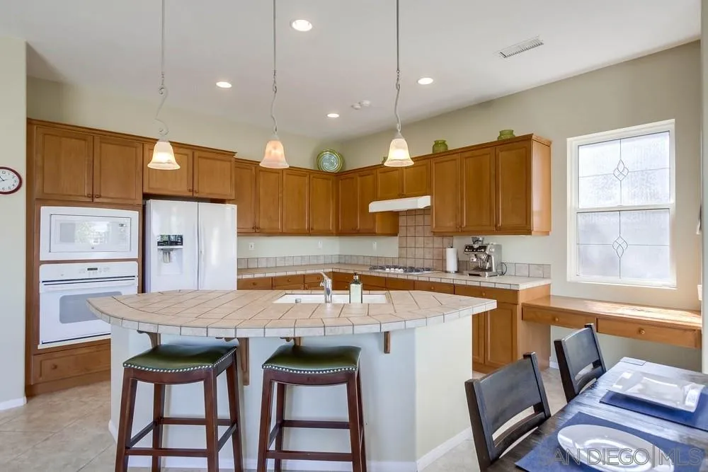 1480 Edgehill Drive Chula Vista, CA 91913 - Photo 11 of 28 a kitchen with a table chairs sink and cabinets