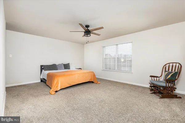 a bedroom with a bed a couch and a window