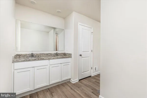 a bathroom with a granite countertop sink and a mirror