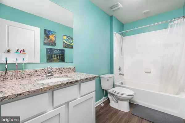 a bathroom with a granite countertop sink toilet and shower