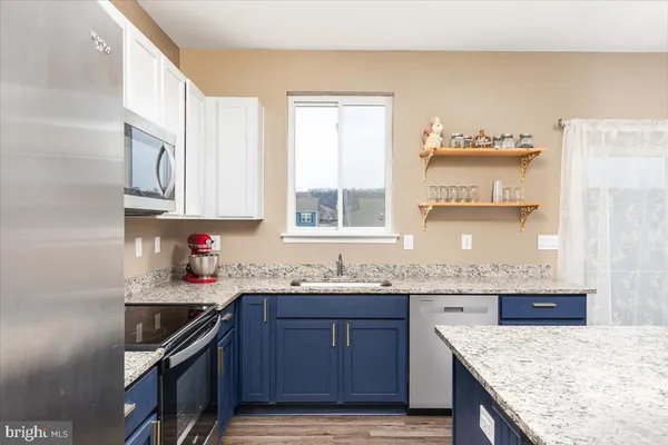 a kitchen with granite countertop a sink stove and cabinets