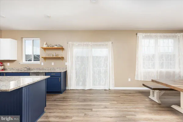 a view of a kitchen with granite countertop a sink and dishwasher with wooden floor