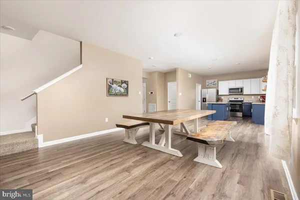a living room with furniture a table and wooden floor