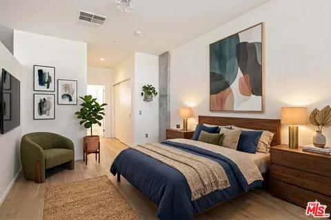a bedroom with a bed and a painting on the wall