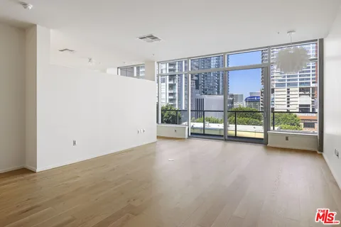 a view of room with wooden floor and floor to ceiling window