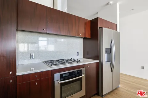 a kitchen with stainless steel appliances granite countertop a refrigerator and a stove