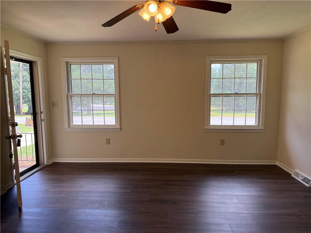 1507 East Calhoun Street Anderson, SC 29621 - Photo 3 of 18 Well-lit living area featuring rich hardwood flooring and large windows inviting ample natural light.