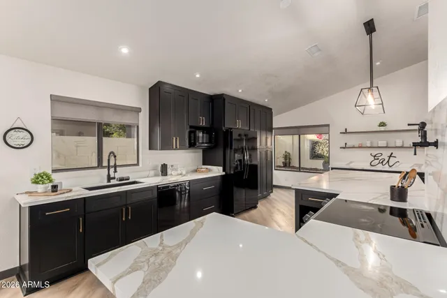 a kitchen with stainless steel appliances granite countertop a sink a stove and a wooden floors