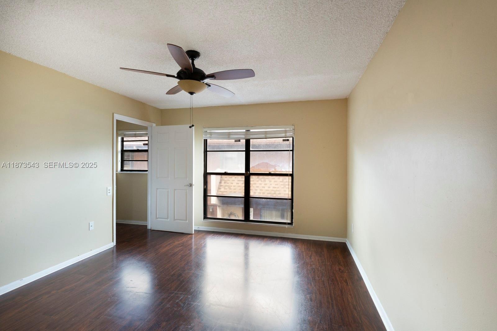 6924 Southwest 114th Place, Unit H56 Miami, FL 33173 - Photo 12 of 19 wooden floor in an empty room with a window